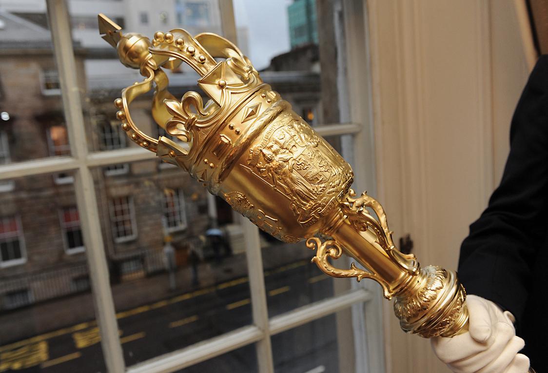 A person holding the College mace