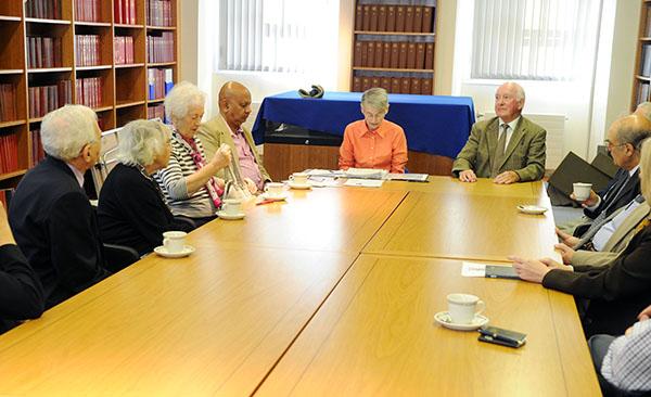 Members of the Senior Fellows' Club sitting around a table in the library