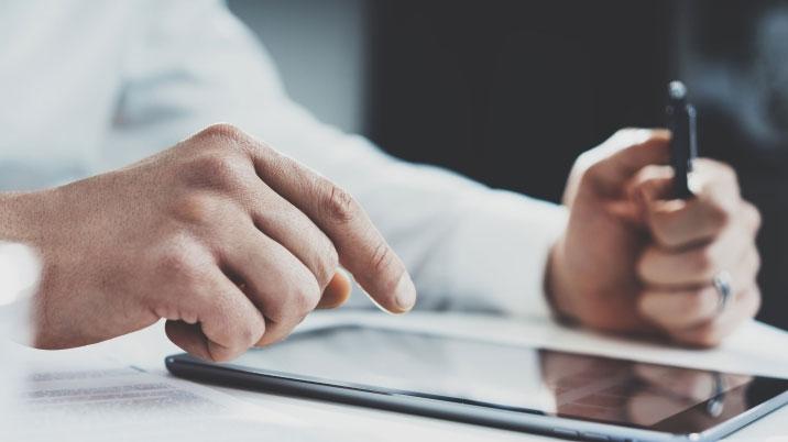 Person with a pen working on a tablet