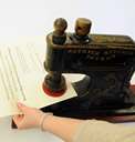 A person using a stamping machine to stamp a letter