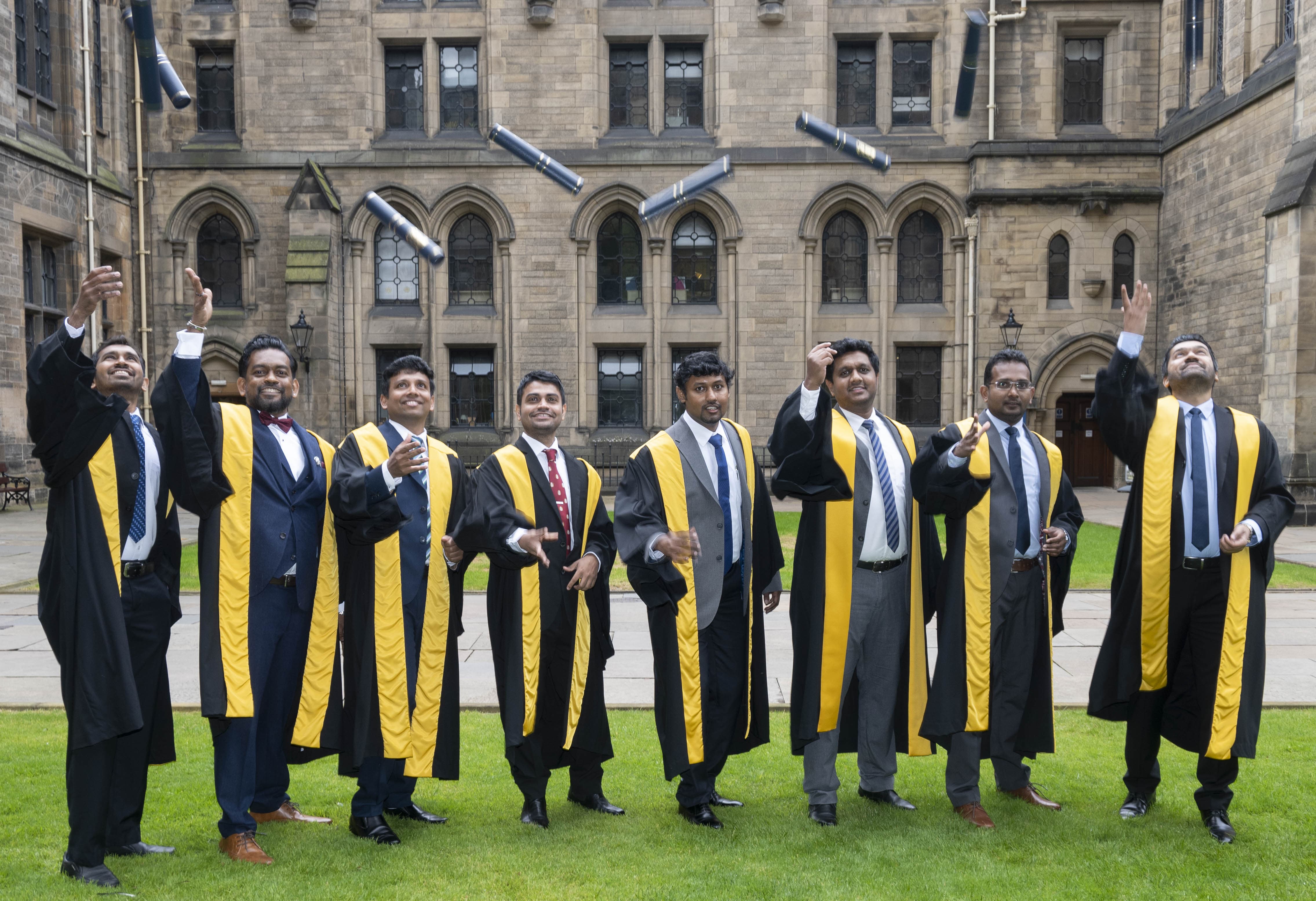 men in ceremonial gowns celebrating their diploma