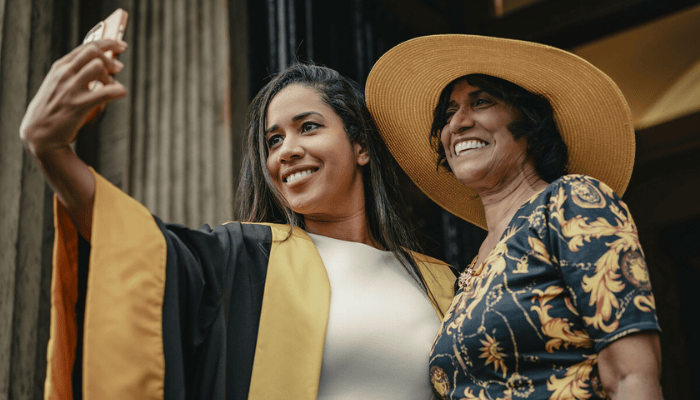 two women taking a selfie, one in ceremonial gowns