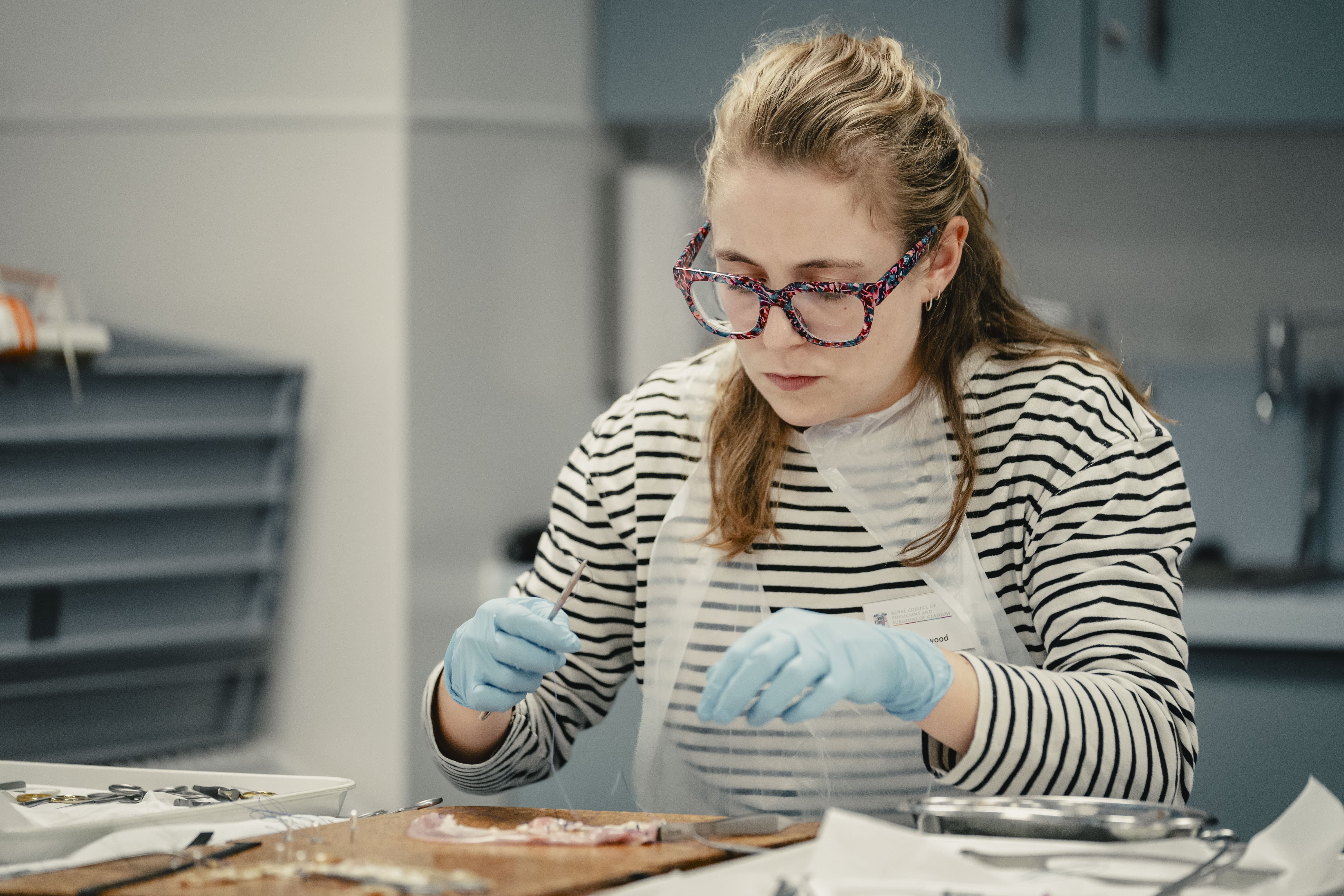 a woman taking part in the basic surgical skills course