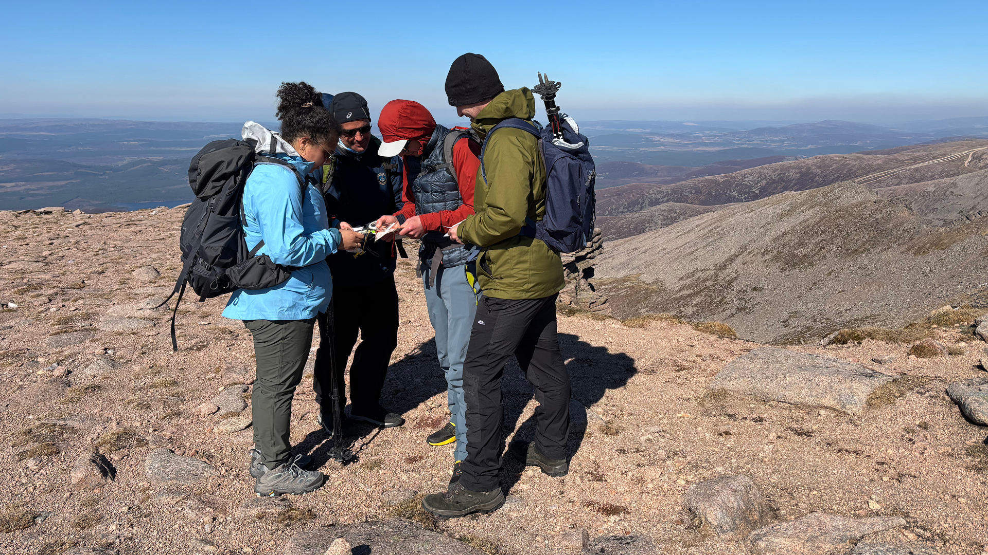 Group of travel medicine expedition participants huddled around a map 