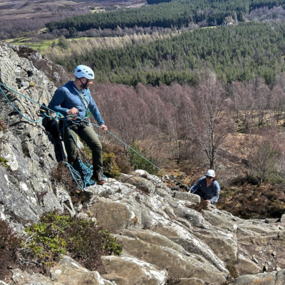 two people helping each other during a hike