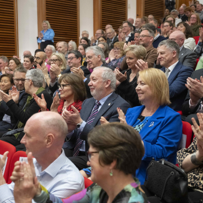 a full lecture theatre of smiling people