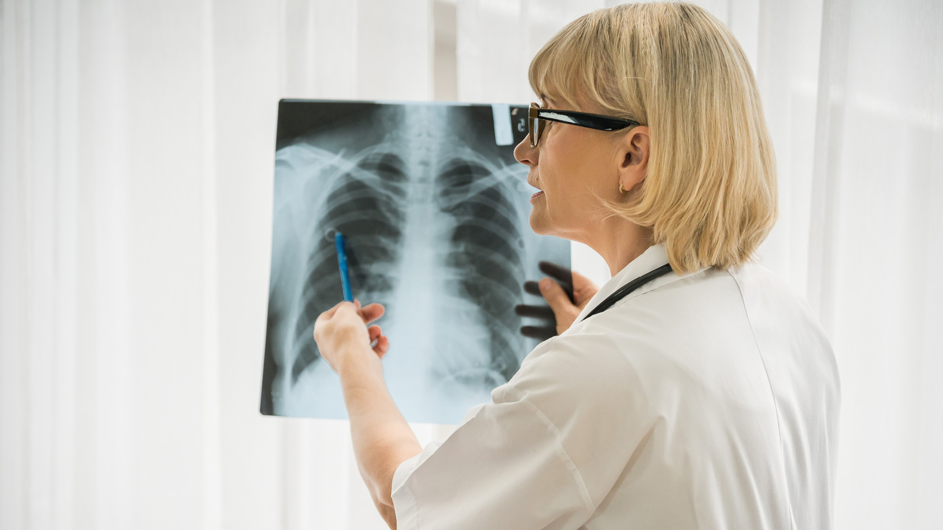 A female clincian examines an X-ray of chest and lungs